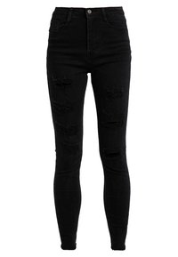 Jeans ajustados de talle alto en negro con detalles desgastados. Están hechos de mezclilla y presentan desgastes en la parte delantera para un aspecto usado.