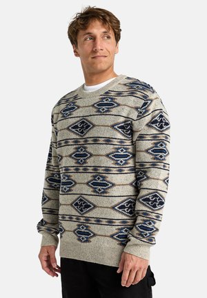 Suéter de punto en gris claro con patrones de diamante y geométricos en azul, cuello redondo y puños y dobladillo acanalados. Textura suave.