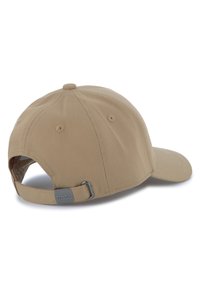 Beige keps med böjd skärm, tillverkad av texturerat tyg. Bakom finns en justerbar rem med en silverfärgad metallaccent märkt "BOSS."