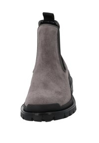 Botín Chelsea de ante gris con panel lateral elástico negro y suela de goma texturizada; cuenta con una lengüeta para facilitar el calzado.