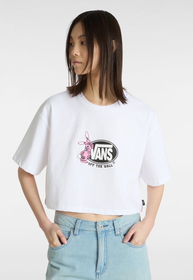 Hvid cropped t-shirt lavet af bomuld, med en pink kanin grafik og sort "VANS Off the Wall" logo på forsiden. Korte ærmer.