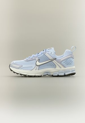 Svijetloplava i bijela sportska cipela s crnim potplatom, mrežastim i sintetičkim gornjim dijelom te istaknutim teksturiranim Nikeovim znakom sa strane.