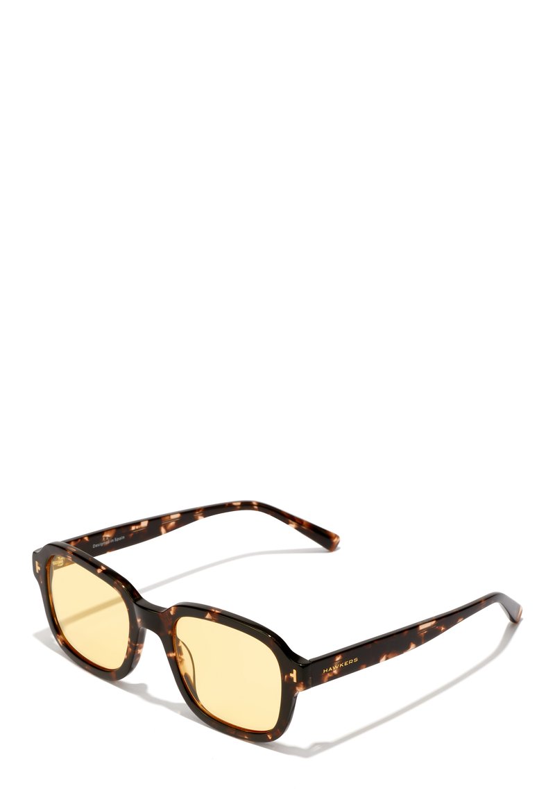 Ochelari de soare tortoiseshell maro cu lentile pătrate și nuanță galbenă. Prezintă brațe elegante cu logo-ul mărcii. Cadru ușor din plastic.