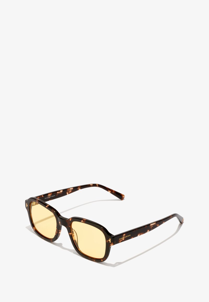 Ochelari de soare tortoiseshell maro cu lentile pătrate și nuanță galbenă. Prezintă brațe elegante cu logo-ul mărcii. Cadru ușor din plastic.