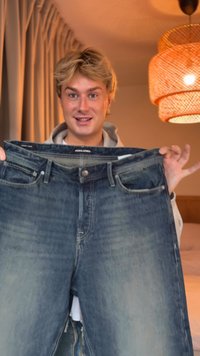 Traperice tamnoplave boje s patentnim zatvaračem, dizajn s pet džepova i suptilnim izbljeđivanjem, prikazane u uspravnom položaju.