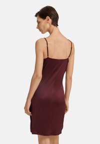 Abito sottoveste in satin bordeaux con spalline sottili e regolabili, texture liscia, silhouette aderente e design lunghezza ginocchio.