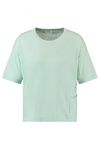 T-shirt verde menta a maniche corte, con taglio adeguato, caratterizzato da un collo rotondo e una tasca laterale. Texture morbida con un design minimale.