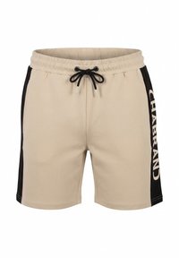Pantalones cortos beige con paneles laterales negros, cintura elástica, cordón negro y texto blanco "CHABRAND" en el panel lateral derecho.
