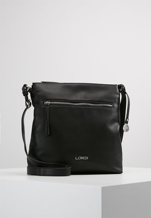Black leather crossbody bag with textured surface, front zip pocket, adjustable strap, and brand logo at the bottom.