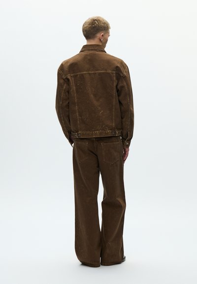 Brown denim jacket with a distressed texture and matching wide-leg pants. Features a classic collar and back pockets. Casual design.