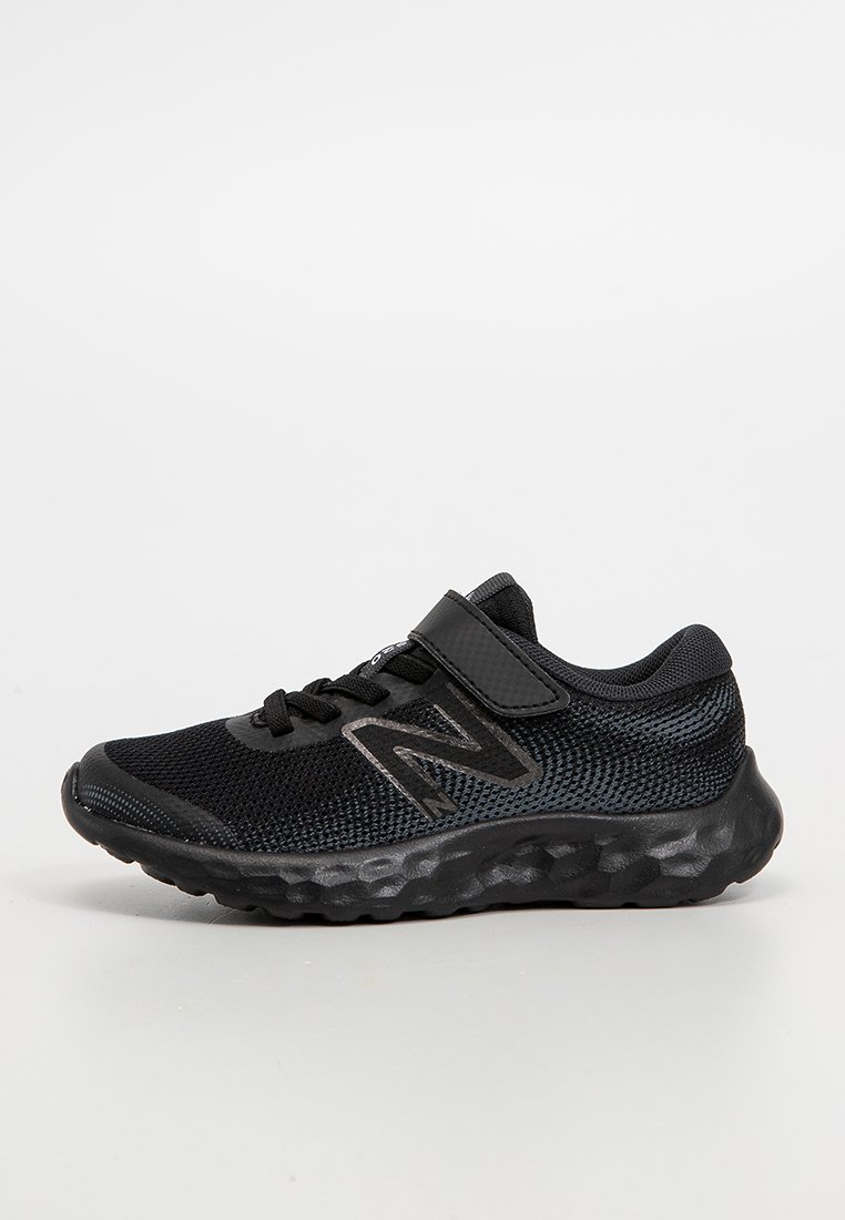 Chaussure de sport noire avec tige en mesh, accents synthétiques, sangle Velcro, semelle texturée et logo contrastant sur le côté.