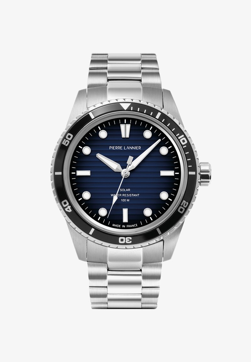 Nerūsējošā tērauda pulkstenis ar zilu rakstu ciparnīcu, saules enerģijas darbināts, ūdensizturīgs līdz 100m, ar sudraba krāsas stundu rādītājiem un rādītājiem.