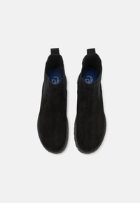 Bottines noirs en daim avec une texture lisse, des panneaux latéraux élastiques et une semelle intérieure contrastante bleue. Bout arrondi et languette pour un enfilage facile.