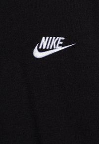 Tricou din bumbac negru, cu un logo alb Nike brodat și swoosh. Textură netedă cu elemente de design minime.