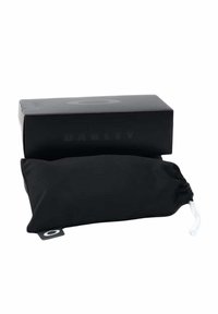 Sacchetto nero con cordino, dalla superficie liscia e opaca, con un cordino bianco. Accompagnato da una scatola rettangolare nera con la scritta "OAKLEY" stampata sopra.