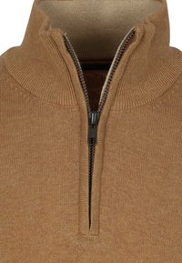 Gebreide pullover in lichtbruin met een hoge kraag, voorzien van een korte rits en een geribbelde textuur. Soepele binnenvoering in een contrasterende kleur.