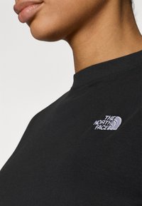 Μαύρο κοντομάνικο μπλουζάκι με στρογγυλή λαιμόκοψη, με μικρό κεντημένο λογότυπο της "The North Face" στην αριστερή πλευρά του στήθους.