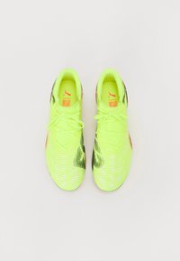 Neon yellow sport shoes with textured mesh upper, black accents, and detailed white pattern. Features flat laces and branded insoles.