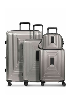 Quattro valigie rigide grigio metallizzato con manici telescopici e ruote girevoli, inclusa una piccola borsa a mano con tracolla.