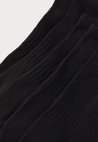 Black crew socks, made of textured fabric with ribbed design, featuring a smooth finish and consistent color across multiple pairs.