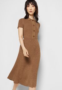 Vestido de malha castanho canelado com mangas curtas, colarinho e fecho de cinco botões. Cintura ajustada e saia fluida, textura lisa por toda a peça.