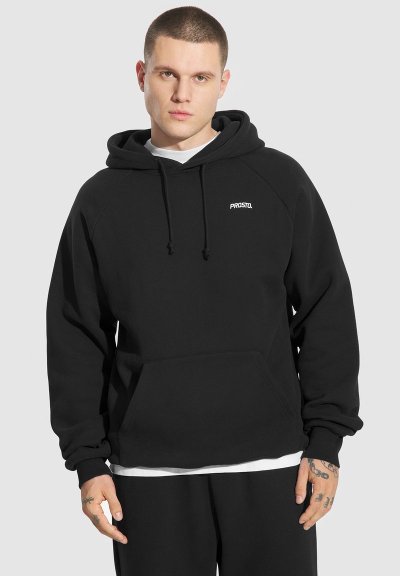 Czarna bluza z kapturem, wykonana z miękkiego materiału, z przednią kieszenią i małym logo na klatce piersiowej. Żebrowane mankiety i luźny krój.