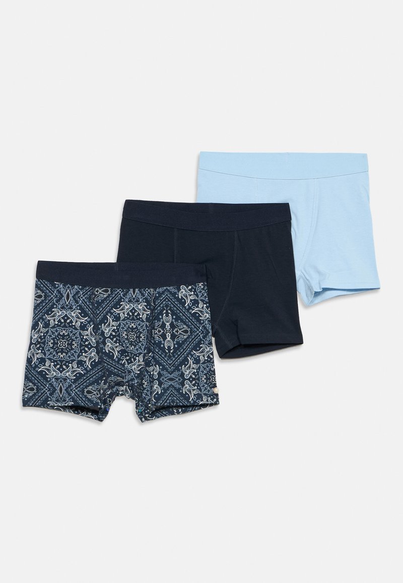 Τρία ζευγάρια ανδρικά σλιπ μποξεράκια σε ανοιχτό μπλε, μονόχρωμο ναυτικό μπλε και ναυτικό μπλε με λευκό μοτίβο σε στιλ μαντήλι, τοποθετημένα επίπεδα σε λευκό φόντο.