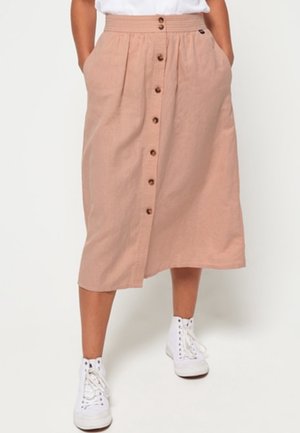 Jupe midi rose clair en lin, présentant une coupe droite, des poches latérales, une fermeture avant à boutons et une taille ajustée.