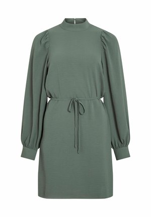 Žalia suknelė su ilgomis pūkuotomis rankovėmis, aukštu iškirpimu, raišteliu juosmenyje ir lygiu paviršiumi. Paprastas, tiesus siluetas, iki kelių.