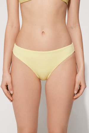 Culotte de bikini jaune avec un motif texturé et en relief. La taille est large et les découpes des jambes sont de coupe moyenne pour un ajustement confortable.