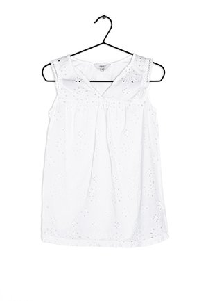 Weißes ärmelloses Blusenshirt mit floralem Stickerei- und Spitze-Akzenten, das ein V-Ausschnitt-Design und Raffung an der Taille aufweist. Hängt an einem schwarzen Haken.