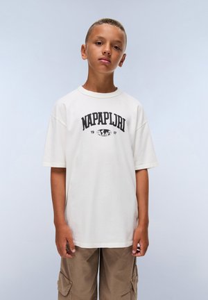 Short-sleeve cream t-shirt with black "Napapijri" logo and established date printed on the front, paired with beige cargo shorts.