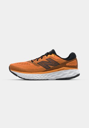 Scarpa da corsa arancione con tomaia in mesh testurizzato, dettagli neri, suola bianca imbottita e lacci neri. Presenta un logo grigio ben visibile.