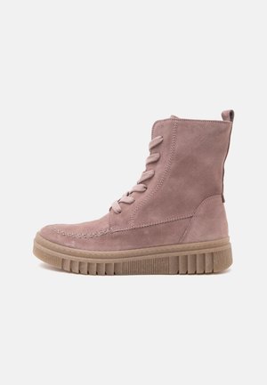 Light pink suede ankle boot with thick ridged beige sole and lace-up front, shown from the side on a white background.