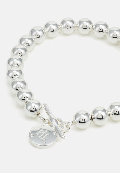 Сребърен мънистенbracelet, включващ гладки, отразяващи сферични мъниста и закопчалка с ключалка. Включва кръгъл медальон с гравирани букви.