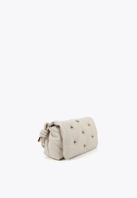 Borsa pochette in pelle beige chiaro con superficie testurizzata, adornata con accenti di borchie dorate. Presenta una tracolla annodata per la chiusura.