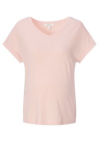 T-shirt rosa chiaro a V con maniche corte, realizzato in tessuto morbido. Caratterizzato da orli arrotolati e una sottile texture lungo le cuciture delle spalle.