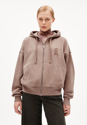 Sweat à capuche zippé marron avec une poche avant, un capuchon réglable par cordon, et un logo brodé sur la poitrine. Tissu doux et texturé.