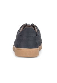 Sneaker in pelle di colore grigio scuro con una finitura texturizzata, collo imbottito e suola in gomma marrone chiaro caratterizzata da un sottile motivo geometrico.