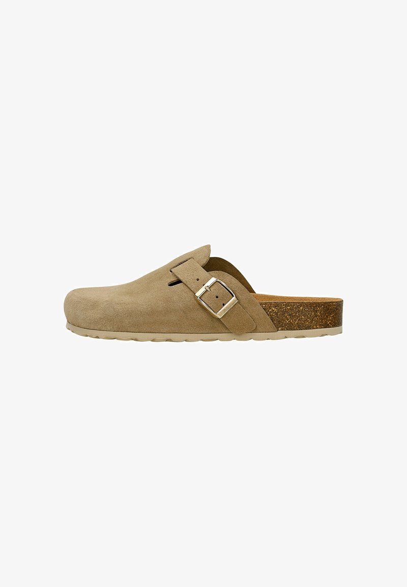 Beige suede klomp met een ronde neus, verstelbare band en een gestructureerde kurken tussenzool. Voorzien van een lichte rubberen outsole met een platte hak.