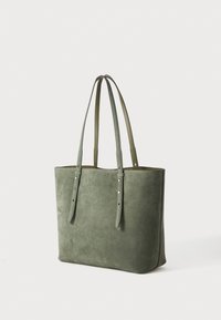 Sac fourre-tout en daim vert avec deux longues poignées, forme rectangulaire, design minimaliste et détails de couture subtils le long des bords.