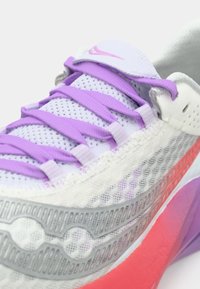 Scarpa da corsa Nike con tomaia in mesh bianco e dettagli in viola e rosa, suola intermedia grigia texturizzata e lacci piatti color lavanda.