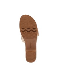 Tan rubber sole with a wavy tread pattern, featuring a rounded shape and smooth surface, designed for traction and comfort.