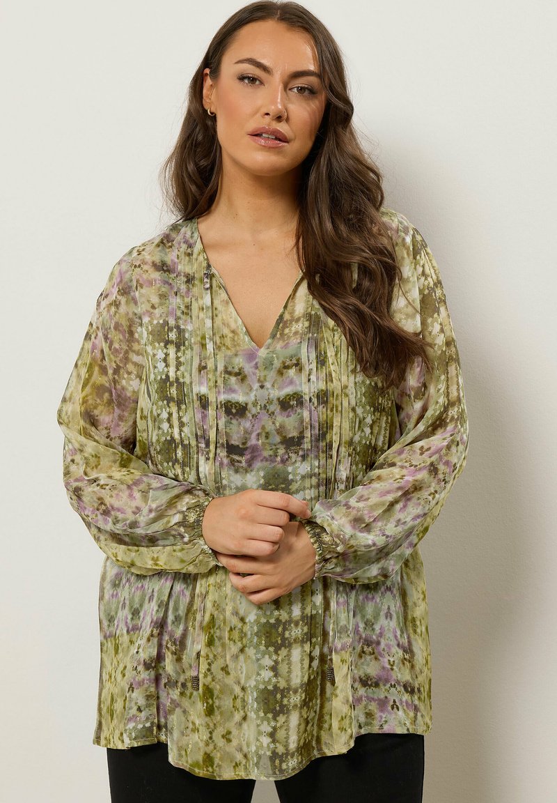 Bluse mit grünem und lila Blumenmuster, langen, elastischen Ärmeln, V-Ausschnitt und plissierten Details. Aus leichtem Stoff gefertigt.