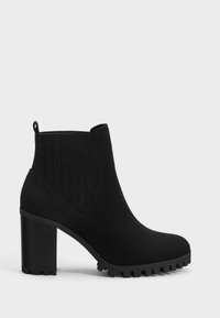 Black suede ankle boot with ribbed textile panels, thick high heel, and rugged sole for traction. Features a pull tab for easy wear.