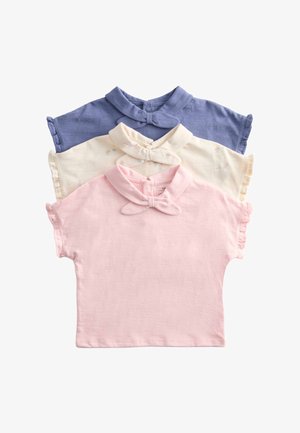 Trzy krótkie koszulki niemowlęce w kolorze różowym, kremowym z nadrukiem babeczki i niebieskim, każda z kołnierzykiem z kokardą i guzikami z przodu.