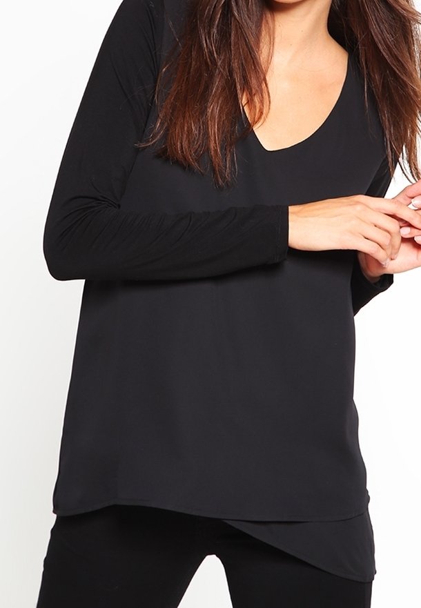 Top noir à manches longues avec un décolleté en V, fabriqué en tissu doux. Présente une coupe décontractée et un ourlet légèrement arrondi, avec un design minimaliste.