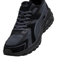 Scarpa sportiva nera e grigia con tomaia in rete testurizzata, dettagli in suede e suola in gomma con battistrada a motivo. Logo Puma sulla linguetta.