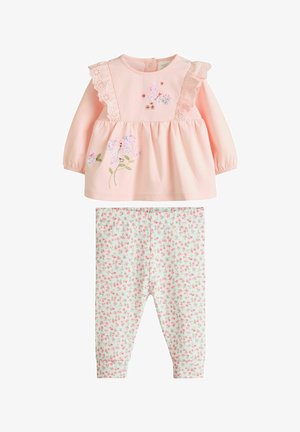 Rosa langærmet top med blonder og blomsterbroderi, parret med lysegrønne leggings med et lille blomster mønster.