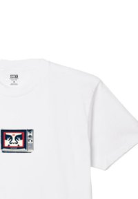 Tricou alb din bumbac, cu un grafic imprimat reprezentând un televizor vintage, având fețe stilizate de culoare neagră și roșie în interiorul ecranului.